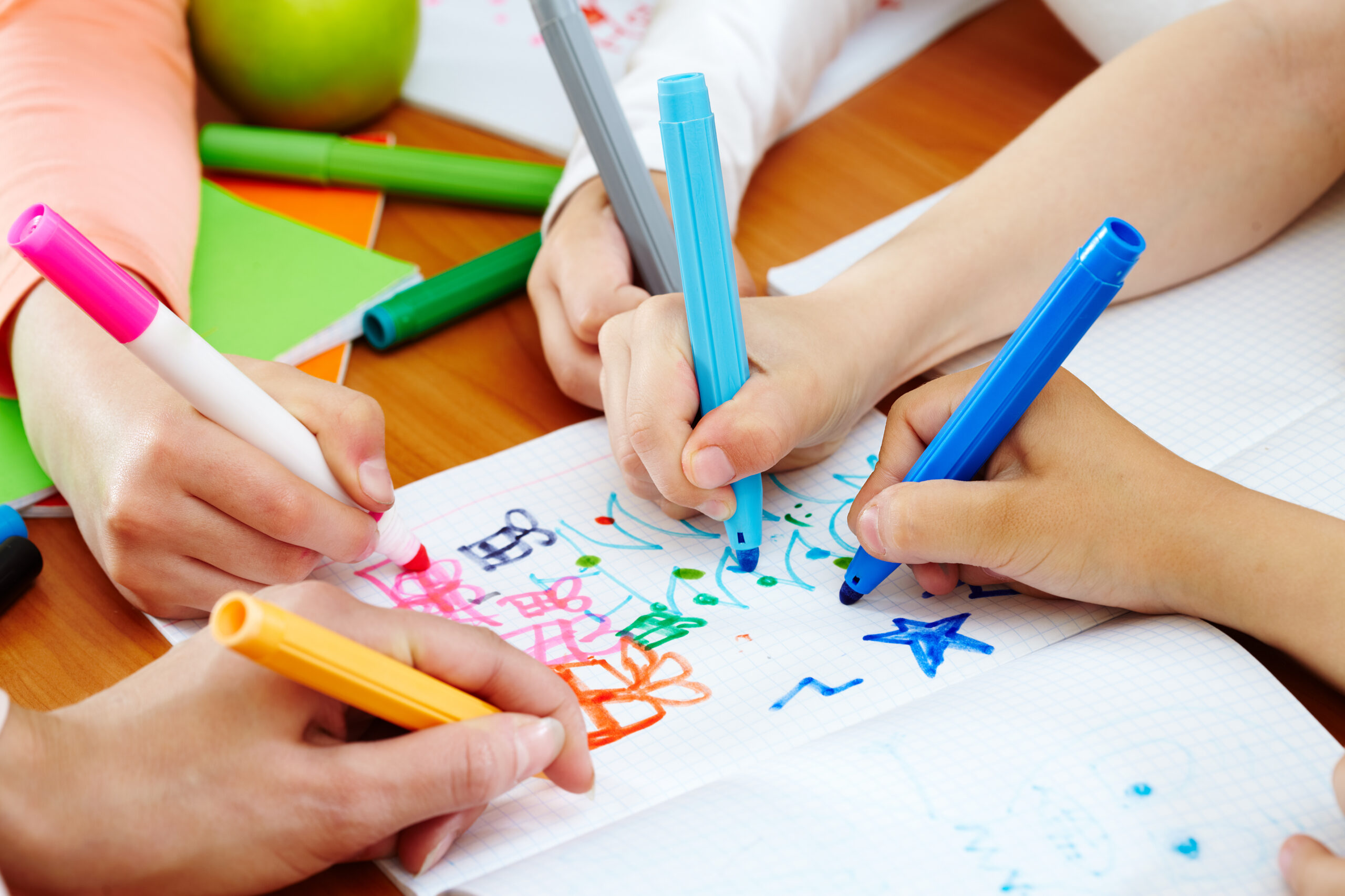 Close-up of human hands drawing with colorful highlighters